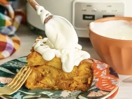 spooning cream cheese over french toast on a plate.